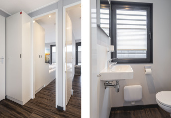 Corridoio e bagno moderni su una houseboat con pavimento in legno e luce naturale, Offingawier, Paesi Bassi.