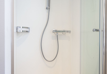 Doccia moderna con porta in vetro e rubinetteria cromata su una houseboat a Offingawier, Frisia, Paesi Bassi.