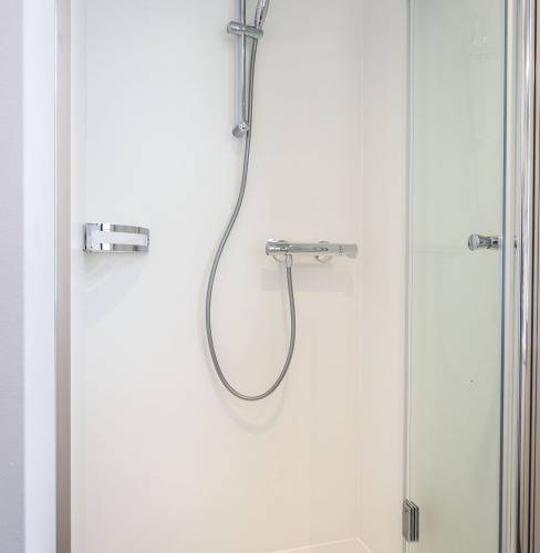 Ducha moderna con puerta de vidrio y grifería cromada en una casa flotante en Offingawier, Frisia, Países Bajos.