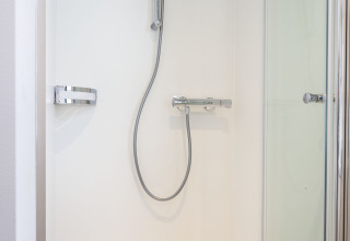 Douche moderne avec porte en verre et accessoires chromés sur une péniche à Offingawier, Frise, Pays-Bas.
