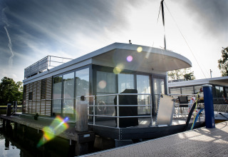 Casa flotante moderna con terraza en la azotea en el muelle en Offingawier, Friesland, Países Bajos.