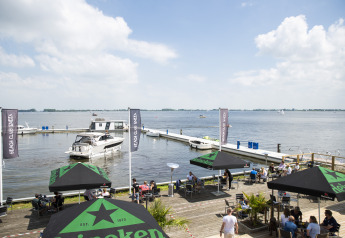 Péniche avec terrasse sur le toit à Offingawier, Frise, vue sur l'eau avec terrasse de café en plein air.