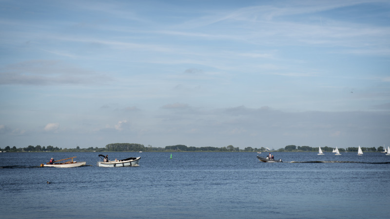 Vista del lago con botes y veleros desde Houseboat + roof terrace en Offingawier, Friesland, Países Bajos.