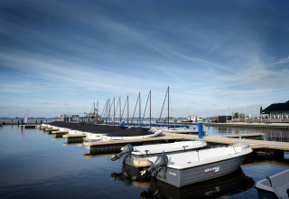 Både ved kaj ved Houseboat + roof terrace i Offingawier, med roligt vand og blå himmel i Friesland.
