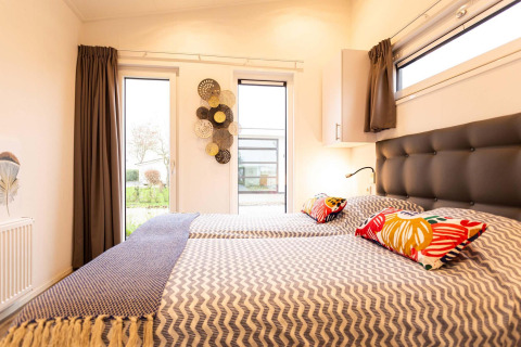 Slaapruimte met tweepersoonsbedden in Nature Lodge Wellness (Spa) bij Park Westerkogge, Nederland.