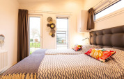 Slaapruimte met tweepersoonsbedden in Nature Lodge Wellness (Spa) bij Park Westerkogge, Nederland.