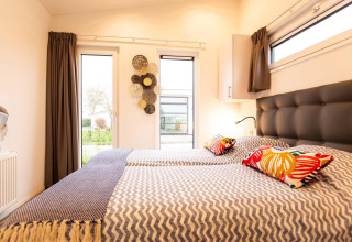 Slaapruimte met tweepersoonsbedden in Nature Lodge Wellness (Spa) bij Park Westerkogge, Nederland.