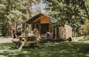 Familia disfruta de un picnic al aire libre frente a la moderna Wikkelhouse en Beerze Bulten, Países Bajos.