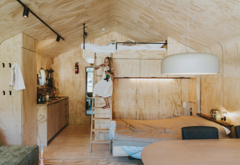 Interieur van de houten Wikkelhouse-lodge bij Beerze Bulten in Nederland met een hoogslaper en kind.