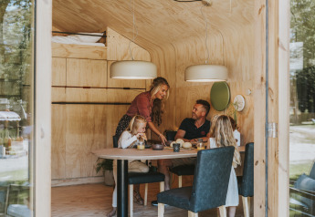 Familia compartiendo una comida en una cabaña de madera en Wikkelhouse, Beerze Bulten, Países Bajos.