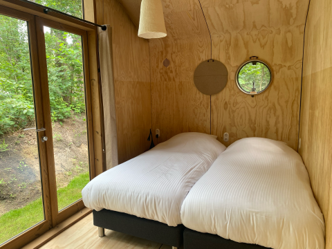 Habitación de cabaña de madera moderna en Wikkelhouse Duo, Beerze Bulten, Países Bajos, con dos camas.
