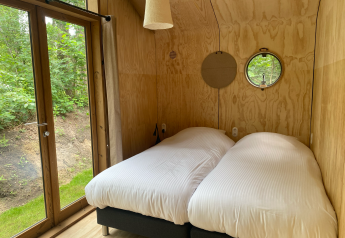 Habitación de cabaña de madera moderna en Wikkelhouse Duo, Beerze Bulten, Países Bajos, con dos camas.