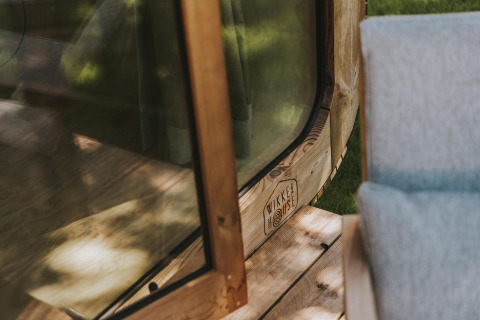 Close-up van houten raamkozijn en terras bij Wikkelhouse Duo lodge in Beerze Bulten, Nederland.