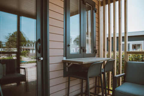 Kleine moderne veranda aan het Tiny Court huisje in Holiday park De Boshoek, Nederland, met stoelen en tafel.