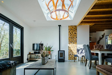 Sala moderna en Nature House, Buitengoed Ruysbos, Países Bajos, con tragaluz y detalles en madera.