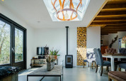 Moderne stue i Nature House, Buitengoed Ruysbos, Holland, med ovenlys, trævæg og træmøbler.