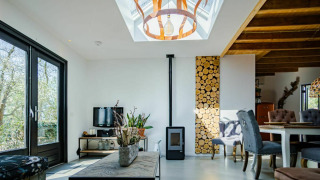 Moderne stue i Nature House, Buitengoed Ruysbos, Holland, med ovenlys, trævæg og træmøbler.