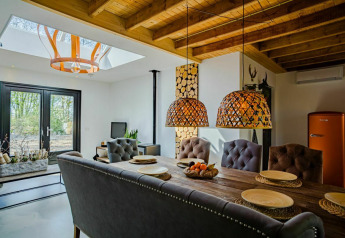 Interno accogliente del Nature House lodge a Buitengoed Ruysbos, Paesi Bassi, con sala da pranzo rustica.