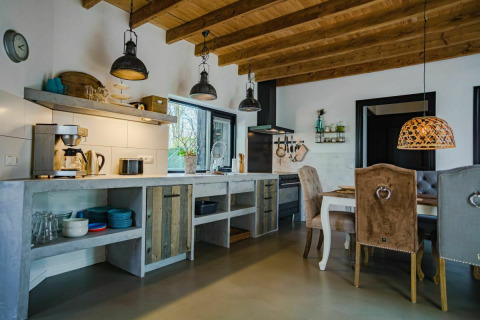 Moderne landelijke keuken en eethoek in Nature House, Buitengoed Ruysbos, Nederland, met houten plafond.