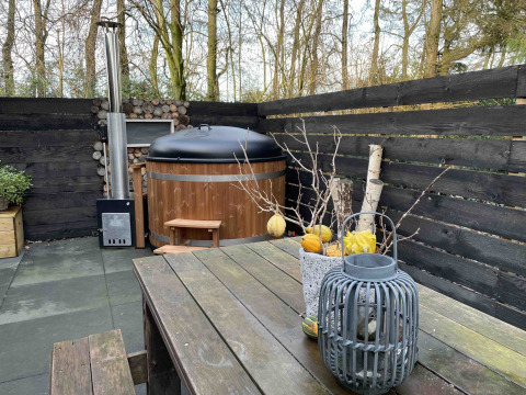 Terrasse extérieure au Nature House, Buitengoed Ruysbos, Pays-Bas, avec bain nordique et table en bois.