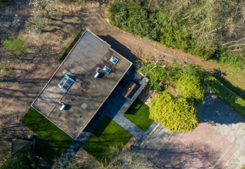 Aerial view of Nature House lodge at Buitengoed Ruysbos, Netherlands, surrounded by trees and pathways.