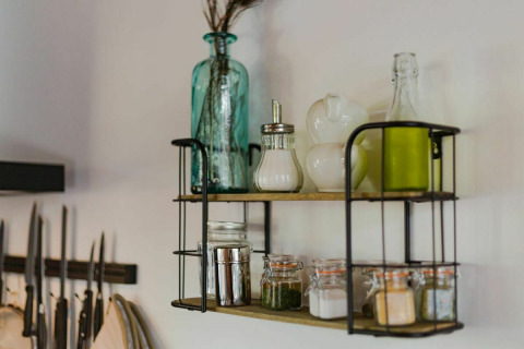 Open kitchen shelf at Nature House, Buitengoed Ruysbos, displaying bottles, jars, and spices.