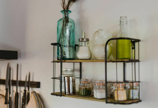 Open kitchen shelf at Nature House, Buitengoed Ruysbos, displaying bottles, jars, and spices.