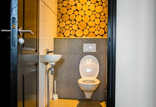 Toilettes modernes avec mur en rondins de bois au Nature House, Buitengoed Ruysbos, aux Pays-Bas.