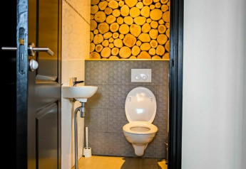 Modern toilet met houten boomstammenwand in Nature House, Buitengoed Ruysbos, Nederland.