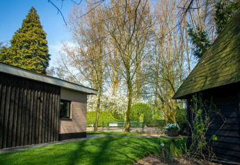 Photo d’un lodge paisible et d’un jardin verdoyant au Nature House, Buitengoed Ruysbos, Pays-Bas, au printemps.