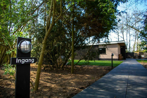 Entrance to a nature house lodge at Buitengoed Ruysbos in the Netherlands, with trees and pathway.