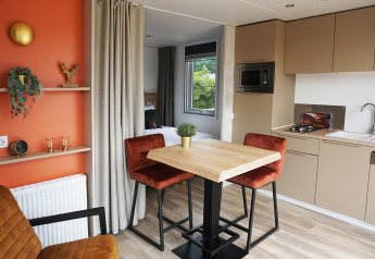 Moderne tiny house Hotel Lodge met keuken, eethoek en gezellige inrichting bij De Boshoek, Nederland.