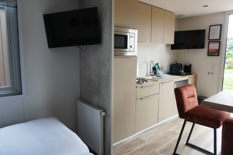 Foto di una tiny house con cucina moderna e camera da letto all’Hotel Lodge, Holiday park De Boshoek, Paesi Bassi.