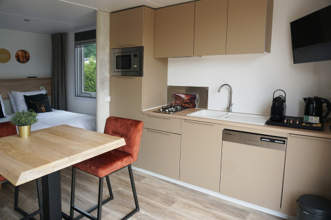 Tiny house hotel lodge kitchen and dining area at Holiday park De Boshoek, Netherlands, with modern design.