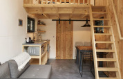 Interno di una tiny house a Maasduinen, Paesi Bassi, con soppalco, cucina compatta e zona pranzo.