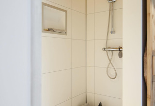 Doccia moderna in Tiny House a Maasduinen, Paesi Bassi, con soffitto in legno e design bianco minimalista.