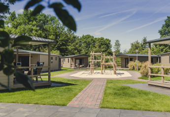 Vista exterior del lodge 6x bungalette en Holiday Park Mölke, Países Bajos, con parque infantil y áreas verdes.