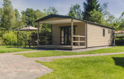 Moderne 6-persoons bungalette op Vakantiepark Mölke, Nederland, met terras en tuinmeubilair in het groen.