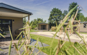 Buitenaanzicht van 6x bungalette bij Holiday Park Mölke in Nederland met speeltuin en groene tuin.