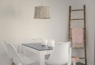 Moderne eetruimte in 6x bungalette bij Holiday Park Mölke, Nederland, met tafel en witte stoelen.