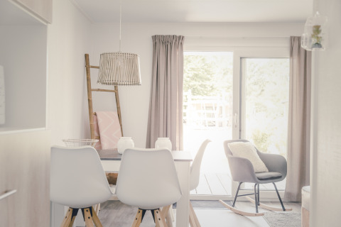Lichte, moderne eetruimte in een 6x bungalette in Holiday Park Mölke, Nederland, met stoelen en tafel.