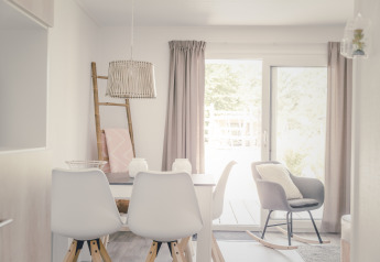 Lichte, moderne eetruimte in een 6x bungalette in Holiday Park Mölke, Nederland, met stoelen en tafel.