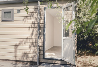 Außenaufnahme einer offenen Tür zu einem hellen 6x Bungalette im Holiday Park Mölke in den Niederlanden.