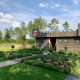 Lodge in legno a forma di castello presso Holiday Park 't Rheezerwold, circondato da giardini verdi.