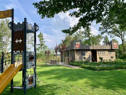 Parque infantil y cabaña de madera temática de castillo en Holiday Park 't Rheezerwold, Países Bajos.