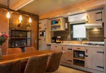 Moderne lodgekeuken en eetruimte in Castle the Pond Gate aan Holiday Park 't Rheezerwold, Nederland.