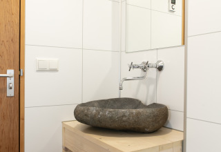 Moderno lavabo de baño con lavabo de piedra en Castle the Pond Gate, Holiday Park 't Rheezerwold, Países Bajos.