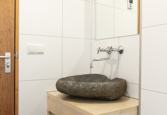 Modernes Badezimmer mit Natursteinwaschbecken in der Lodge Castle the Pond Gate im Ferienpark 't Rheezerwold.
