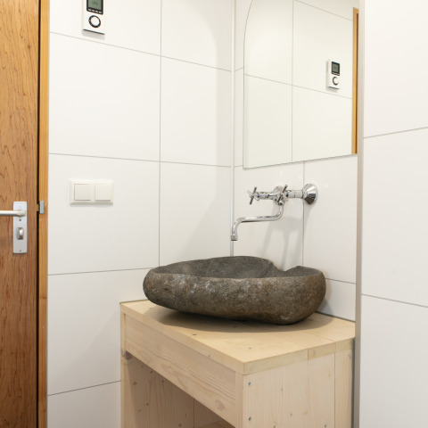 Modernes Badezimmer mit Natursteinwaschbecken in der Lodge Castle the Pond Gate im Ferienpark 't Rheezerwold.