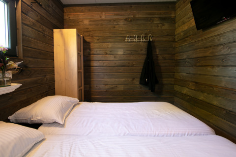 Chambre au Castle the Pond Gate, Holiday Park 't Rheezerwold, Pays-Bas, murs en bois et deux lits simples.